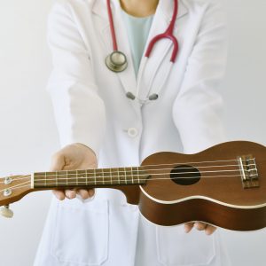 Doctor giving ukulele (musical instrument), Music therapy concept. (Selective Focus)