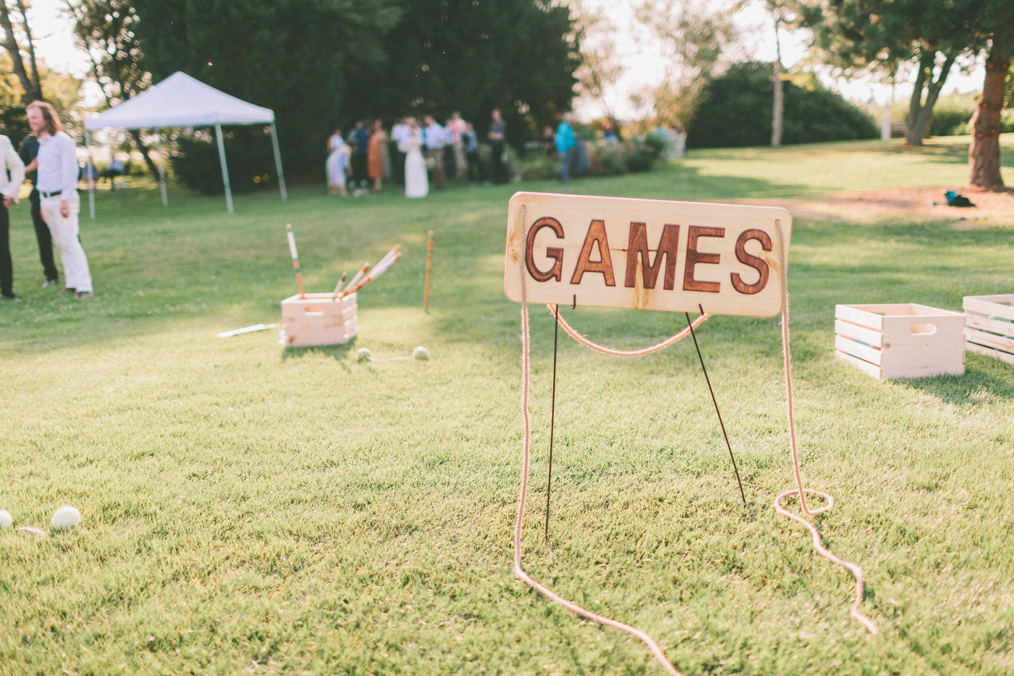 A sign that says ‘games’ set up for lawn games at a wedding.