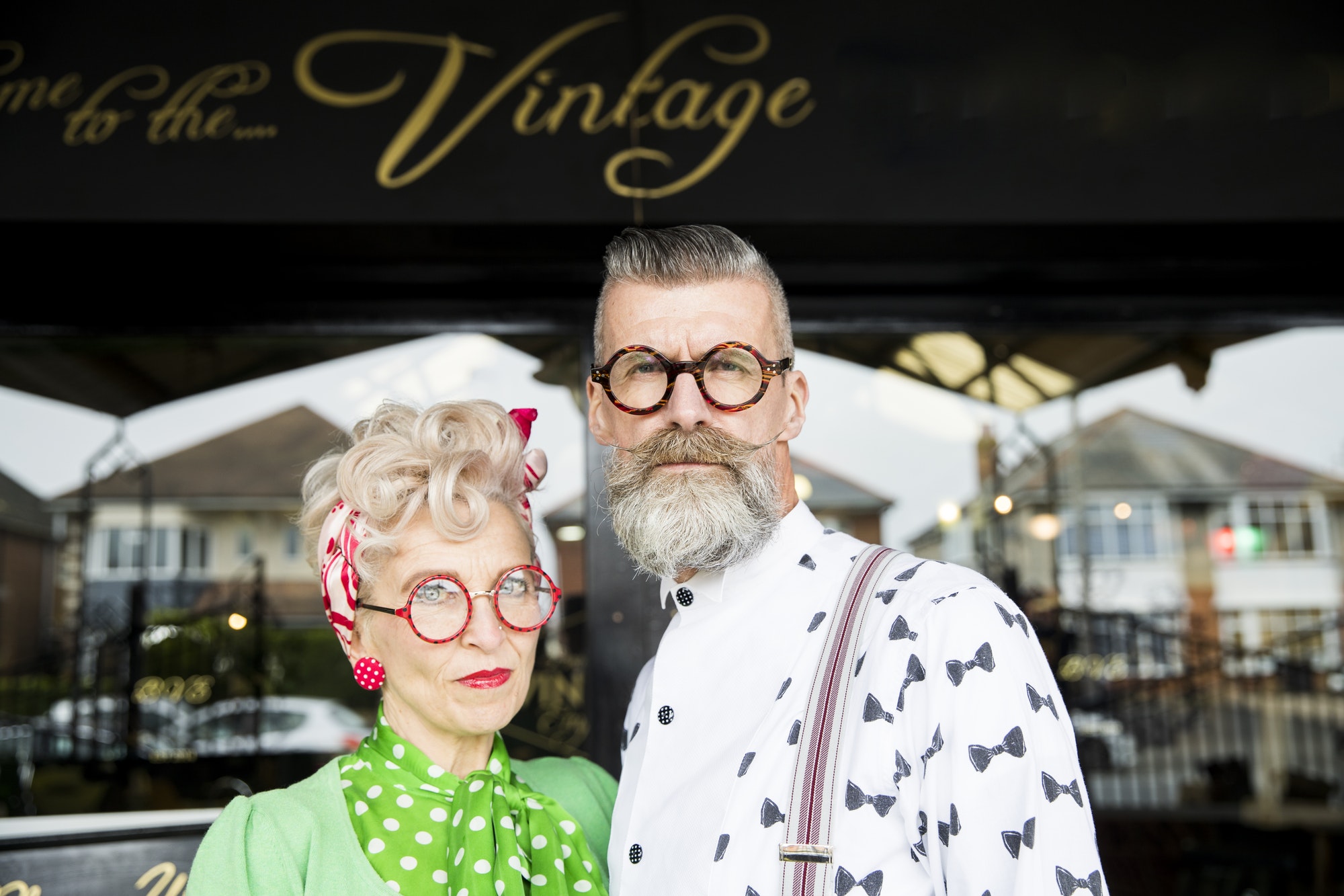 Serious portrait of a quirky vintage couple outside vintage shop