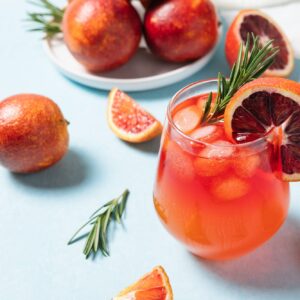 Delicious Blood Orange Cocktail on light blue background.