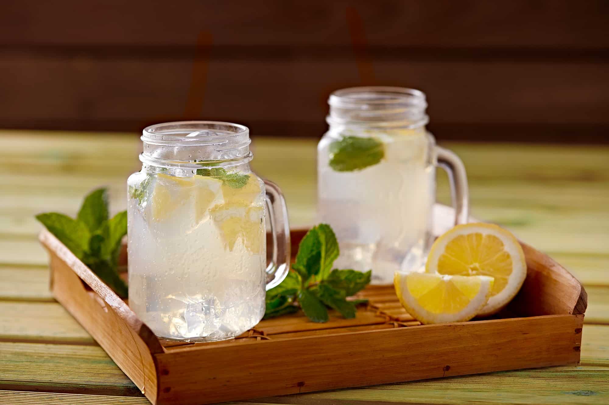 Wooden tray with served refreshing lemonade