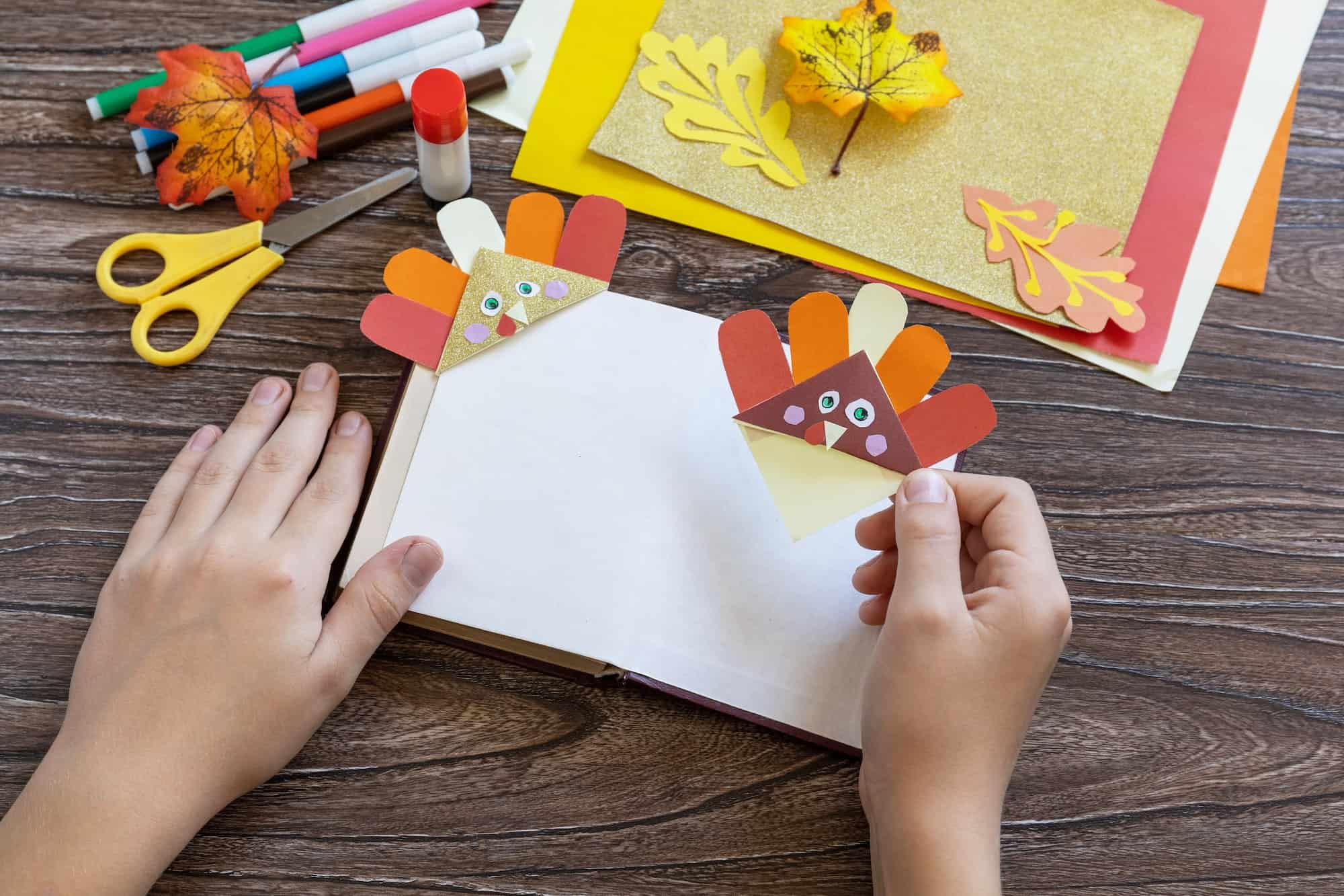 Thanksgiving craft bookmark turkey paper on a wooden table. Childrens art project.