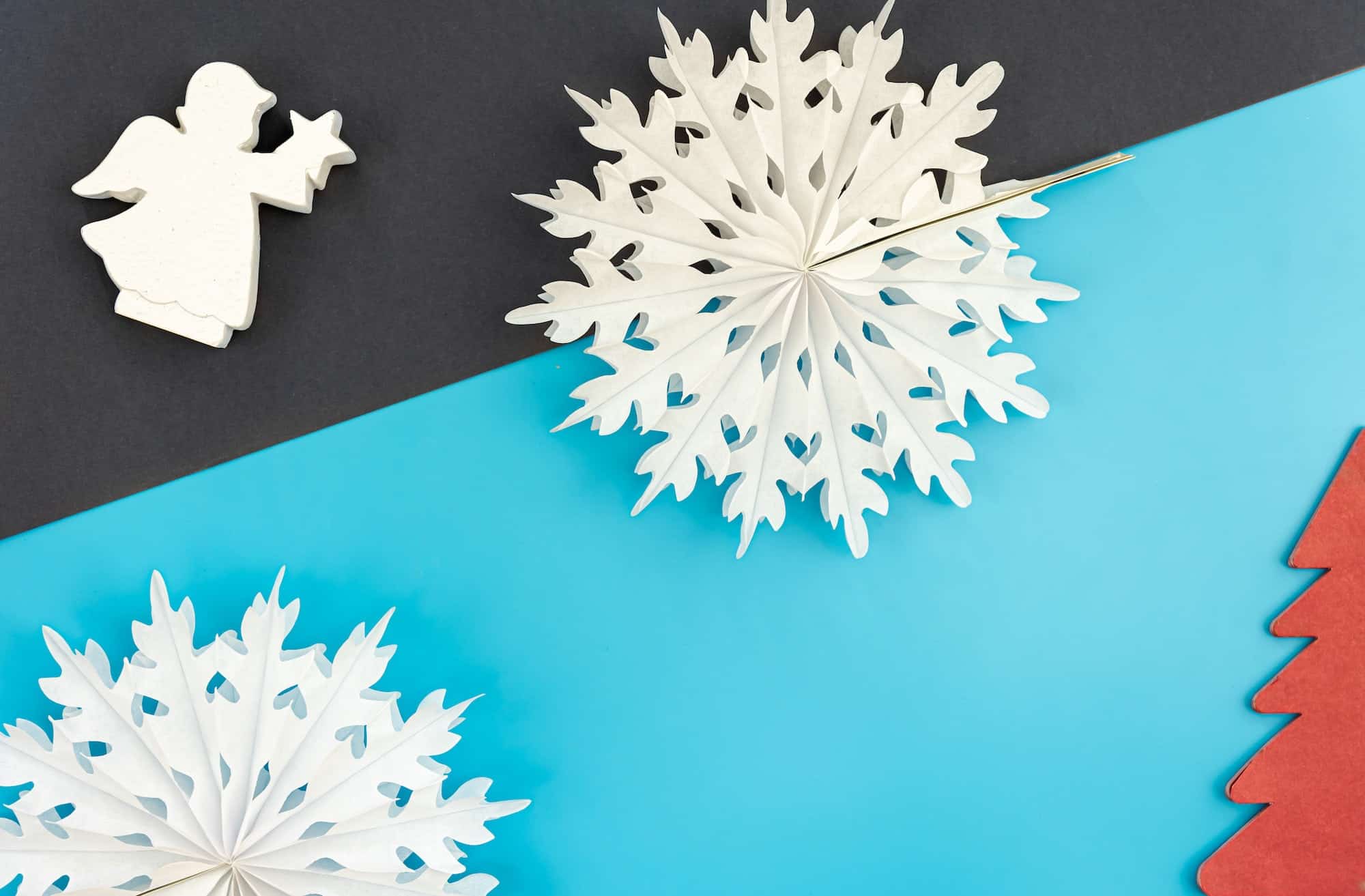 Volumetric paper snowflakes on a colored background, flat lay.